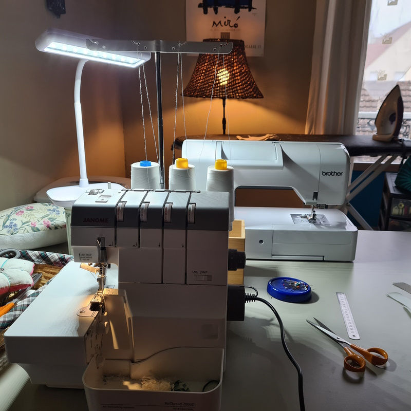 Atelier de couture avec 2 machines à coudre, des ciseaux et des lampes