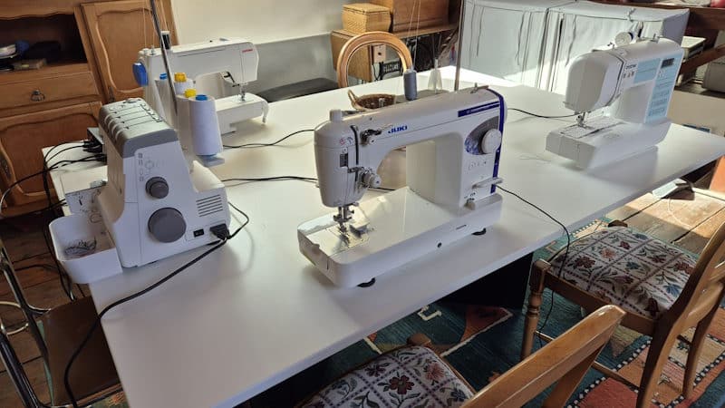 4 Machines a coudre sur une table dans un atelier de couture